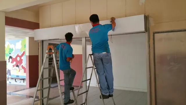Yong Quan installers fitting a roller shutter