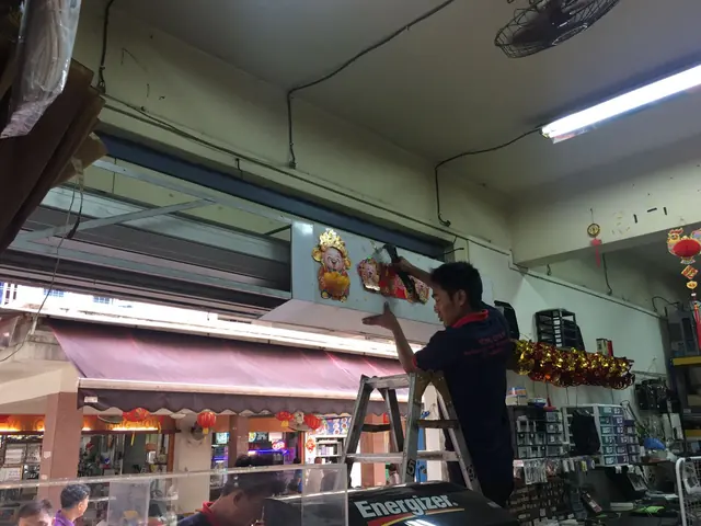 Yong Quan installers fitting a shop roller shutter