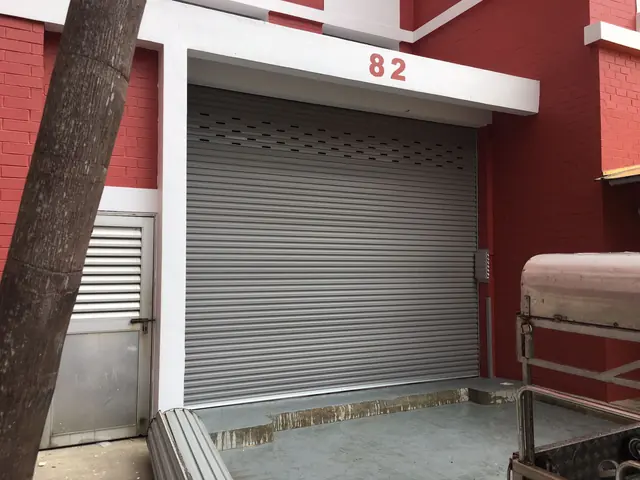 Roller door beside a red-brick residential block
